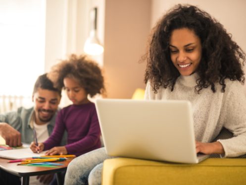 Happy Mother on Laptop in Home in Aurora, CO